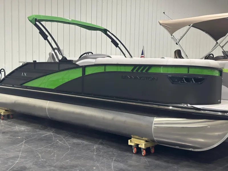 The Image of 2024 Bennington 24LXS pontoon boat with green and black exterior in showroom. - 1