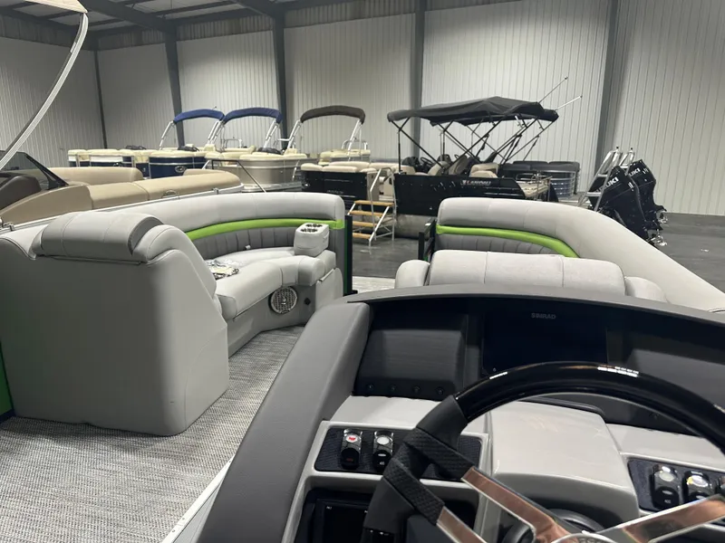 Slide: The Image of 2024 Bennington 24LXS pontoon boat interior with luxurious seating in a showroom. - 13