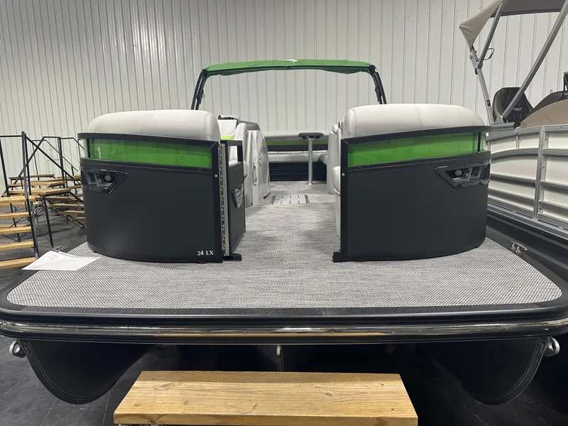 Slide: The Image of 2024 Bennington 24LXS pontoon boat with green accents and spacious seating. - 3