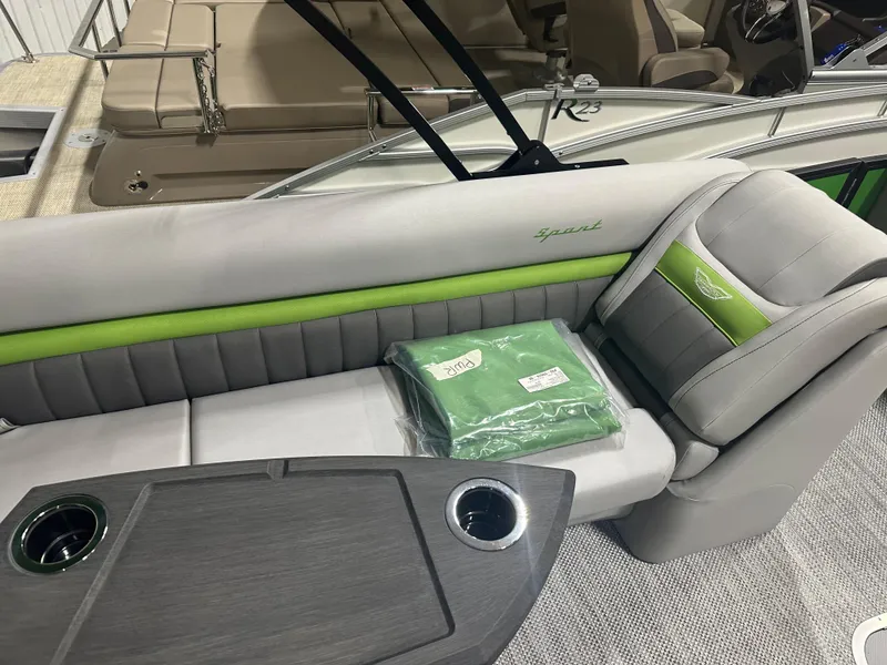 Slide: The Image of 2024 Bennington 24LXS boat interior with gray and green seating and table. - 7