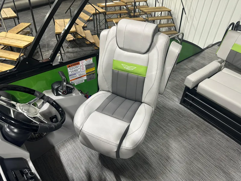 Slide: The Image of Captain's chair of the 2024 Bennington 24LXS pontoon boat with green accents. - 9