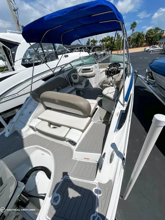 Slide: The Image of 2019 Crownline Eclipse E235 XS boat with blue canopy and spacious seating. - 16