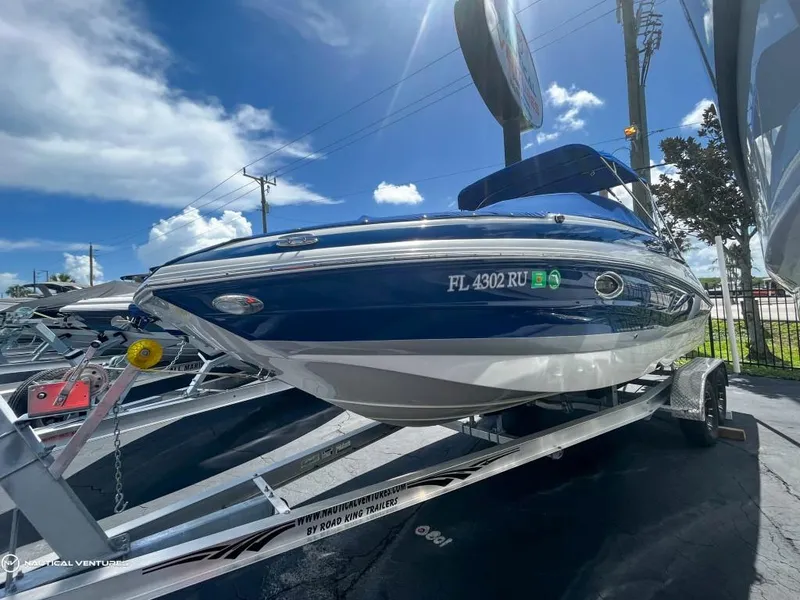 Slide: The Image of 2019 Crownline Eclipse E235 XS boat on a trailer under a sunny sky. - 3