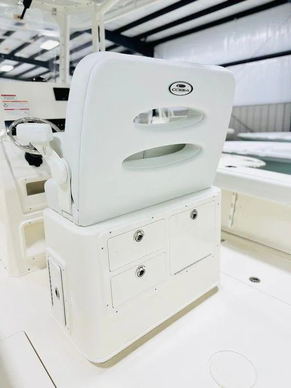 Slide: The Image of 2024 Cobia 240 CC boat interior with white seating and storage compartments. - 10