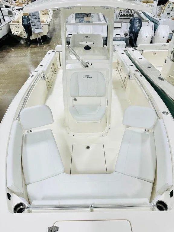 Slide: The Image of 2024 Cobia 240 CC boat interior with seating and console, displayed in a showroom. - 11
