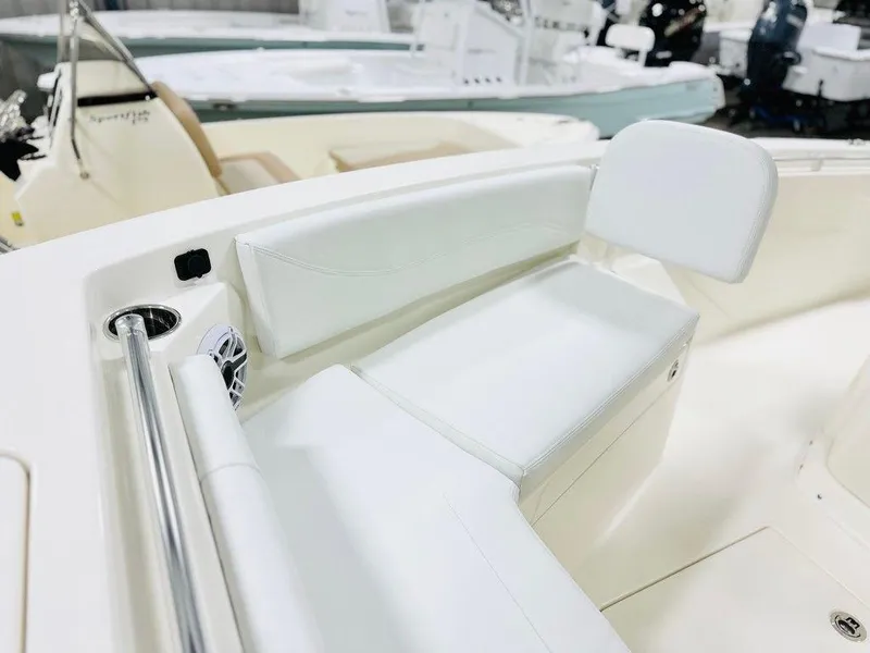 Slide: The Image of 2024 Cobia 240 CC boat interior with white seating and cup holder. - 13