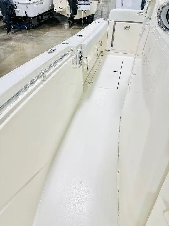 Slide: The Image of 2024 Cobia 240 CC boat interior, featuring spacious white deck and seating area. - 14