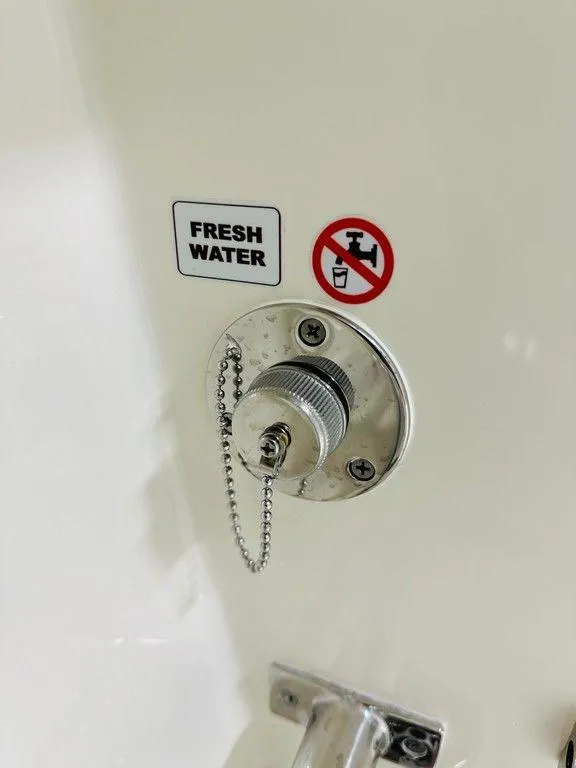 Slide: The Image of Fresh water inlet on 2024 Cobia 240 CC boat with no drinking symbol. - 15