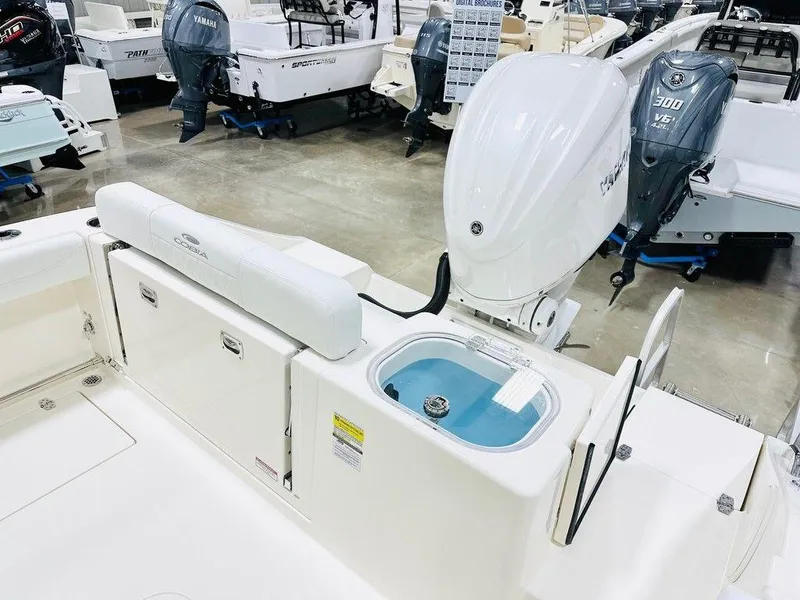 Slide: The Image of 2024 Cobia 240 CC boat interior with Yamaha outboard motor in showroom. - 16
