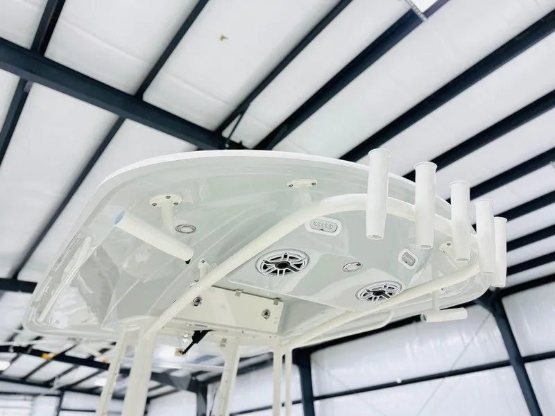 Slide: The Image of 2024 Cobia 240 CC boat top view with rod holders and speakers. - 2