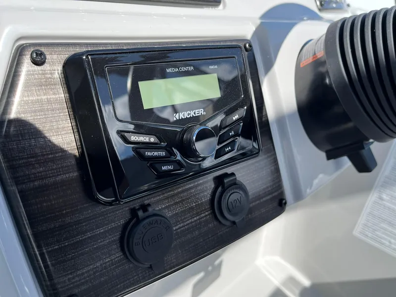Slide: The Image of 2024 Lowe SS 210 boat dashboard with Kicker media center and USB ports. - 10
