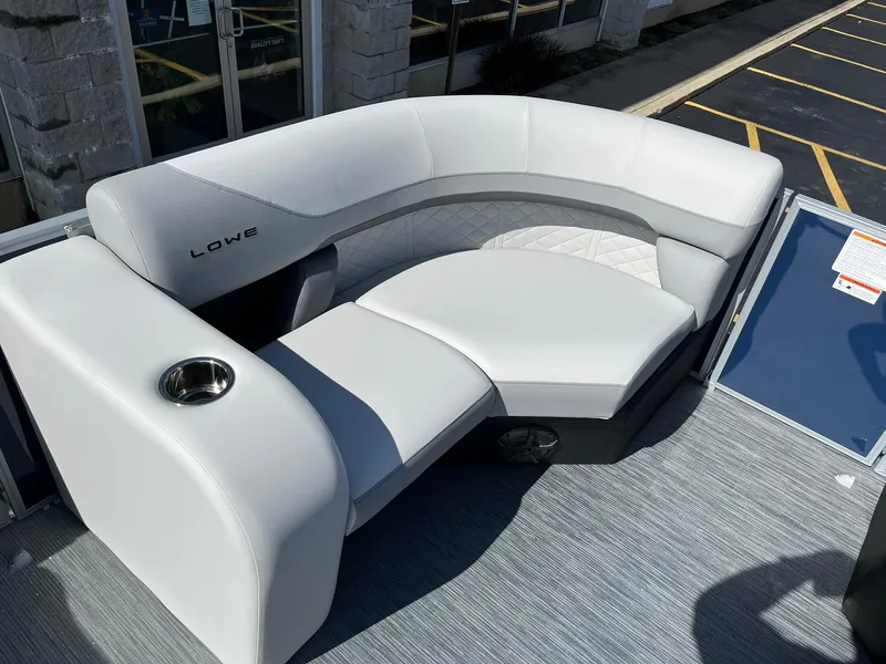 Slide: The Image of 2024 Lowe SS 210 boat with white cushioned seating and cup holder. - 12