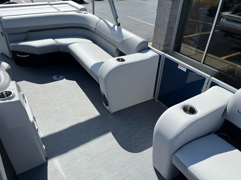 Slide: The Image of 2024 Lowe SS 210 pontoon boat interior with gray seating and cup holders. - 13