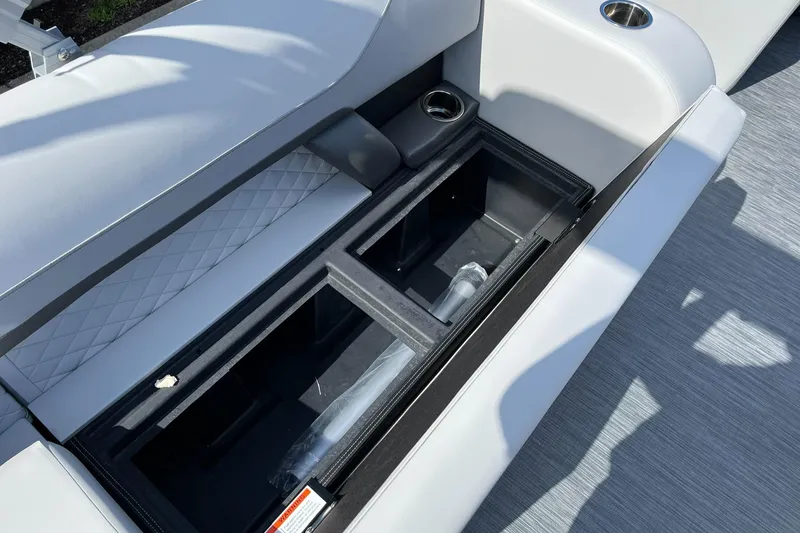 Slide: The Image of 2024 Lowe SS 210 boat storage compartment with cup holders and cushioned seating. - 18