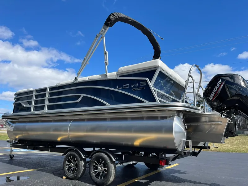 Slide: The Image of 2024 Lowe SS 210 pontoon boat on trailer with Mercury outboard motor. - 2