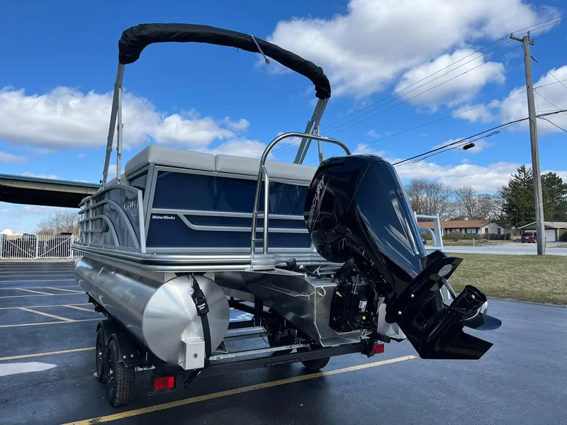 Slide: The Image of 2024 Lowe SS 210 pontoon boat with outboard motor on a trailer. - 23