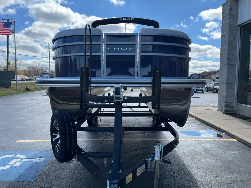 Slide: The Image of 2024 Lowe SS 210 pontoon boat on trailer, front view, blue sky background. - 4