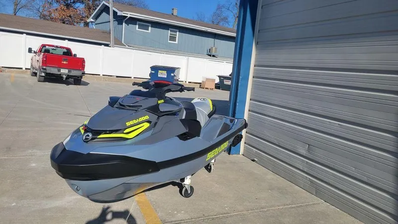 Slide: The Image of 2024 Sea-Doo RXT-X 325 Ice Metal/Manta Green jet ski parked outside. - 3