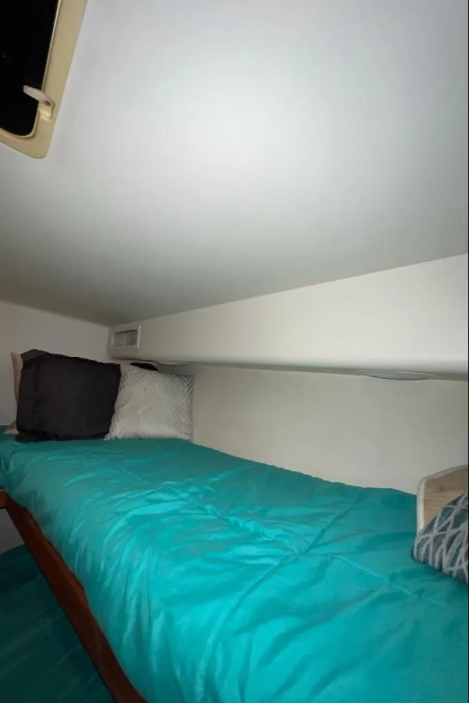 Slide: The Image of Small cozy sleeping area in a 2000 Viking 50 Express boat with teal bedding. - 16