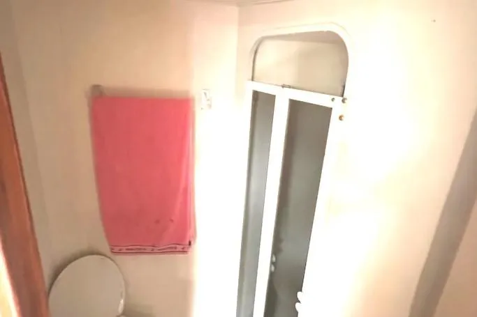 Slide: The Image of Bathroom interior of a 2000 Viking 50 Express boat with shower and pink towel. - 18