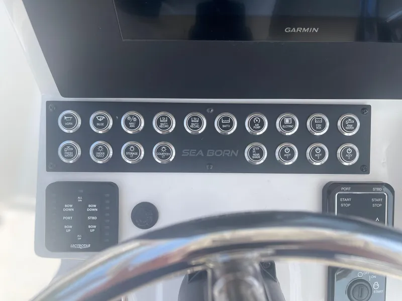 Slide: The Image of Control panel of a 2024 Sea Born LX 24 boat with various switches and Garmin display. - 14