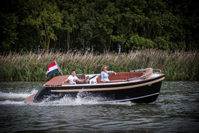 Slide: The Image of 2023 Maxima 620 Retro boat cruising on a river with two passengers. - 12