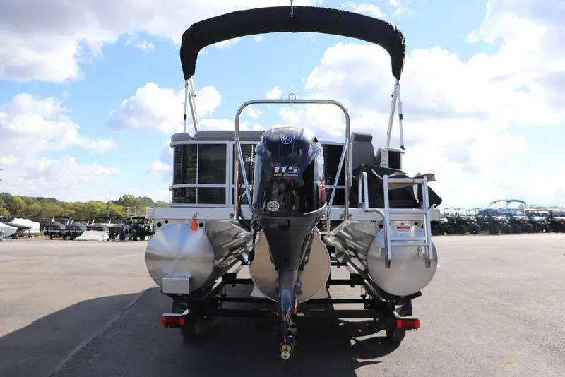 Slide: The Image of 2024 Bennington 20 SL pontoon boat with outboard motor, parked outdoors. - 11