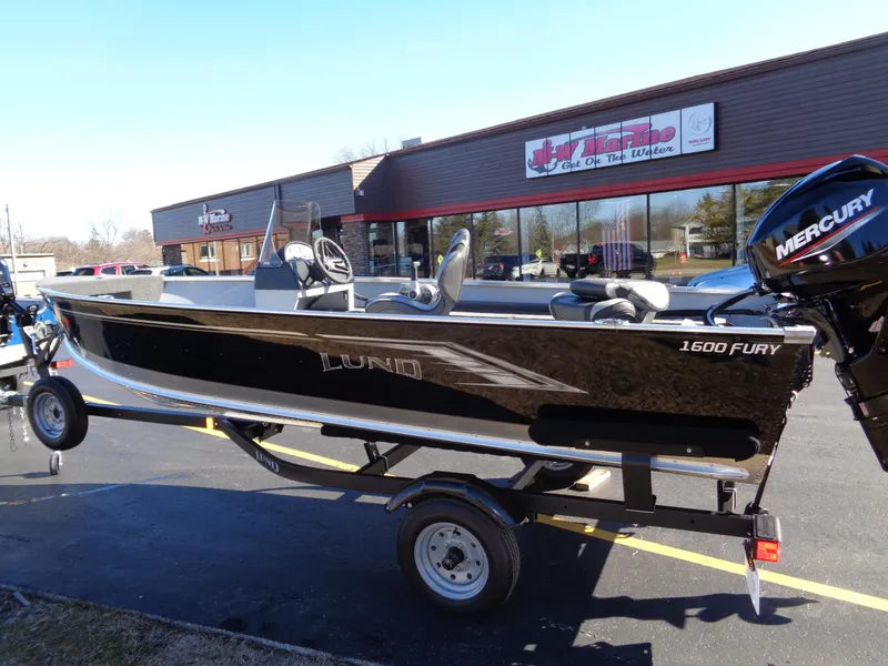 The Image of 2024 Lund 1600 Fury SS fishing boat on trailer, parked outside dealership. - 0