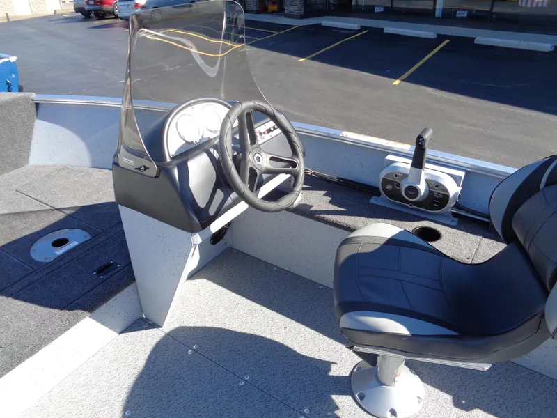 Slide: The Image of 2024 Lund 1600 Fury SS boat interior with steering wheel and captain's chair. - 8