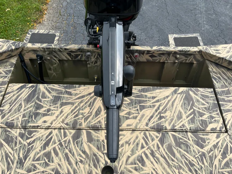 Slide: The Image of 2024 Lowe Roughneck 1660 boat with camo pattern and outboard motor. - 15