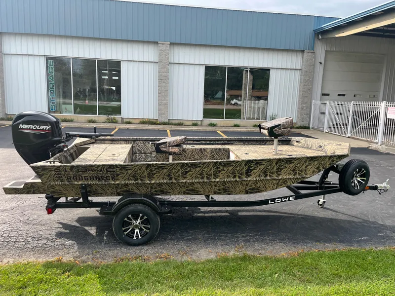 Slide: The Image of 2024 Lowe Roughneck 1660 camo boat on trailer with Mercury outboard motor. - 19
