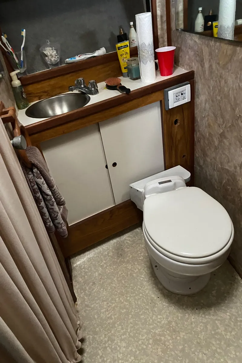 Slide: The Image of 1977 Jersey Dawn 40 boat bathroom with sink, toilet, and toiletries. - 10