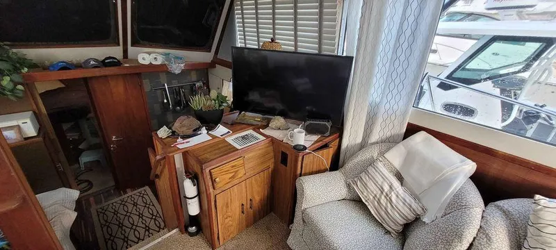 Slide: The Image of Cozy interior of a 1977 Jersey Dawn 40 boat with TV and seating area. - 2