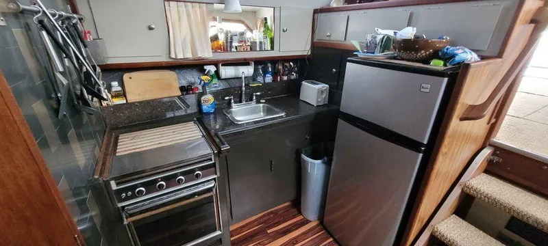 Slide: The Image of 1977 Jersey Dawn 40 boat kitchen with stove, sink, and refrigerator. - 6