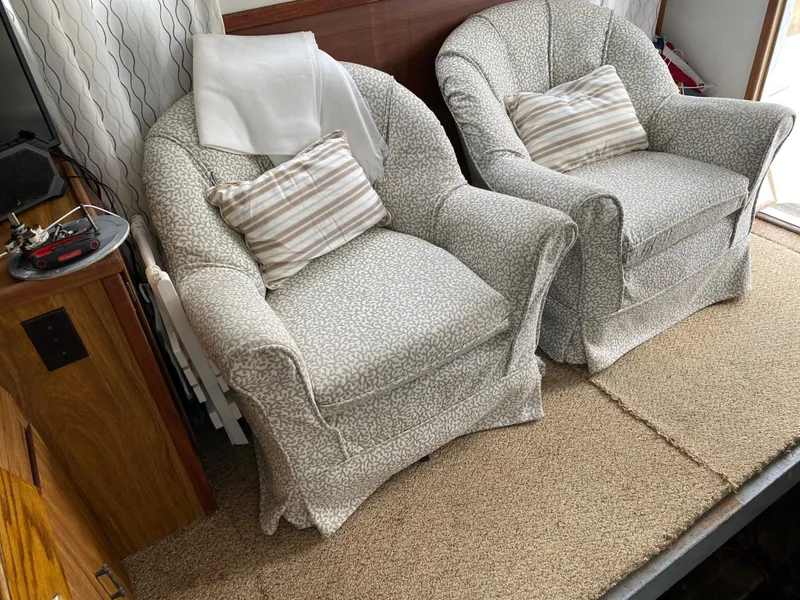 Slide: The Image of Two patterned armchairs with striped cushions in a cozy 1977 Jersey Dawn 40 boat interior. - 7