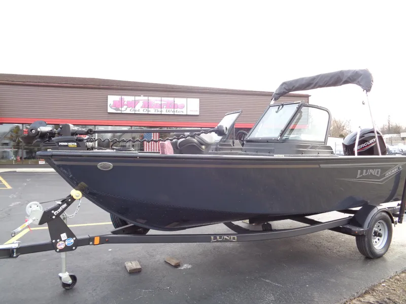 The Image of 2024 Lund 1650 Rebel XL Sport boat on trailer, parked outdoors. - 0