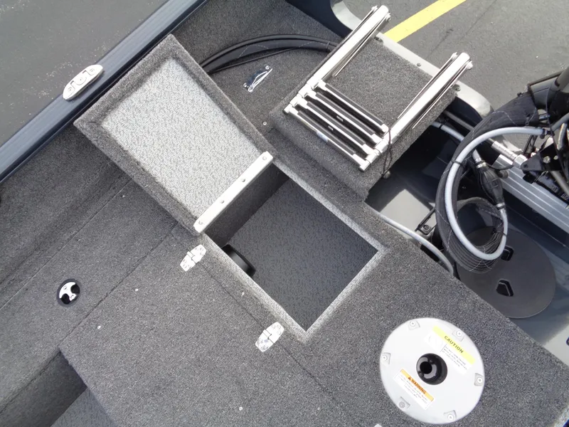 Slide: The Image of 2024 Lund 1650 Rebel XL Sport boat interior with storage compartment and ladder. - 11