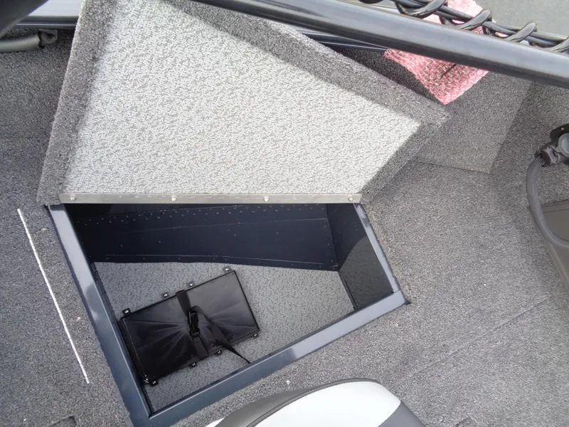 Slide: The Image of 2024 Lund 1650 Rebel XL Sport boat storage compartment with open lid. - 12