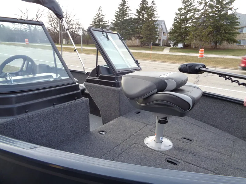 Slide: The Image of 2024 Lund 1650 Rebel XL Sport boat interior with seating and windshield. - 2