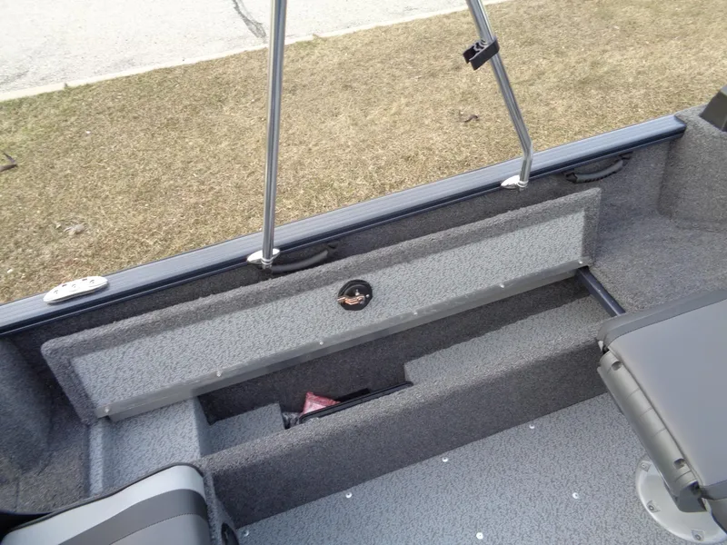 Slide: The Image of 2024 Lund 1650 Rebel XL Sport interior storage compartment with gray upholstery. - 22