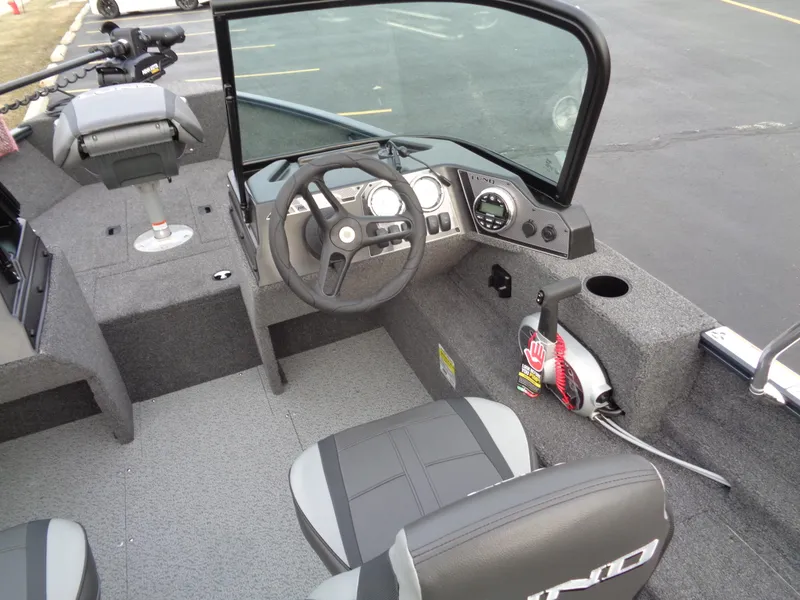 Slide: The Image of 2024 Lund 1650 Rebel XL Sport boat interior with steering wheel and seating. - 34