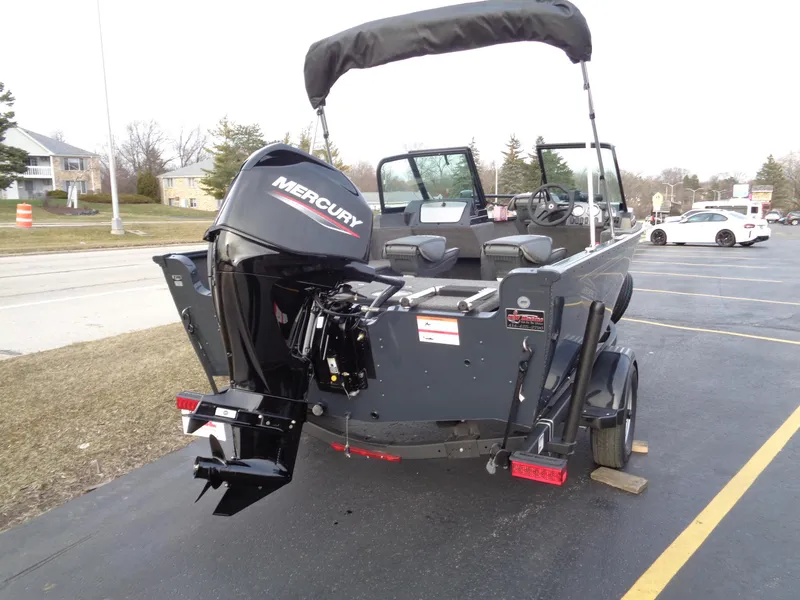 Slide: The Image of 2024 Lund 1650 Rebel XL Sport boat with Mercury engine, parked on a trailer. - 4