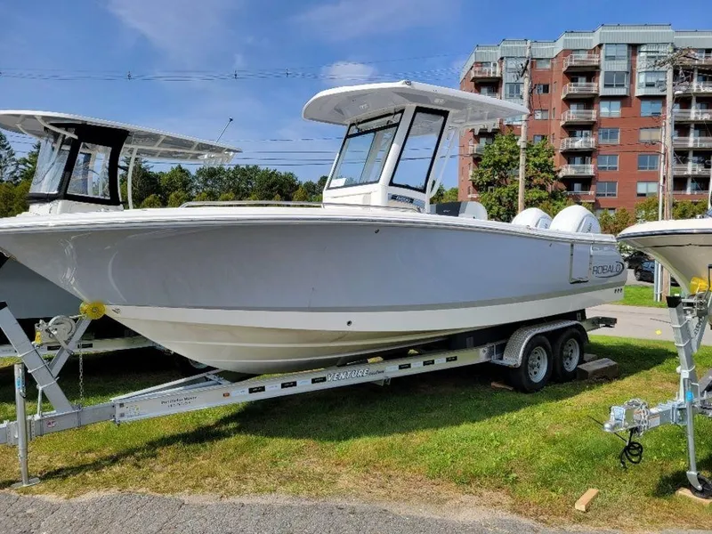 Slide: The Image of 2024 Robalo 250 CC boat on a trailer in an outdoor setting. - 1
