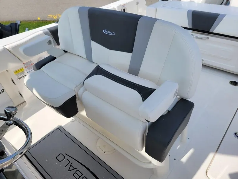 Slide: The Image of 2024 Robalo 250 CC boat with white and black cushioned seating. - 11