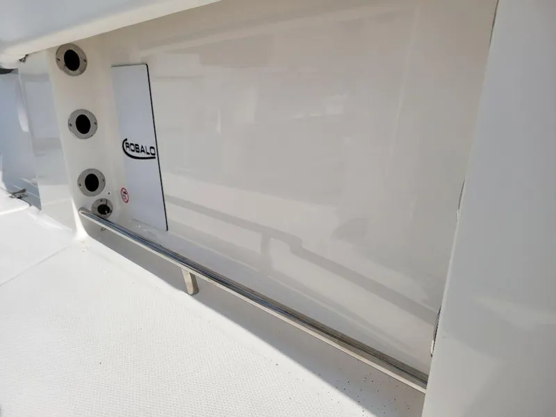 Slide: The Image of 2024 Robalo 250 CC boat interior detail with rod holders and storage compartment. - 12