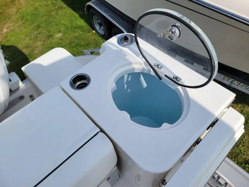 Slide: The Image of 2024 Robalo 250 CC boat livewell with open lid and cup holders. - 21