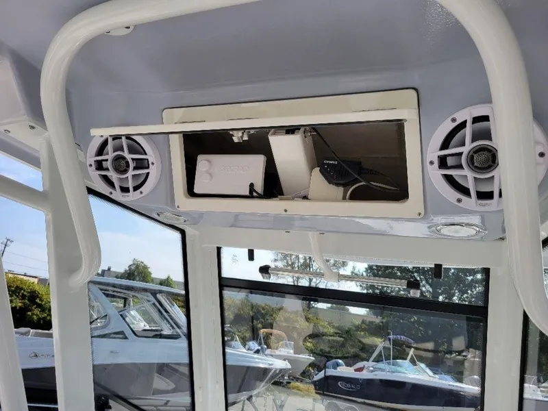Slide: The Image of 2024 Robalo 250 CC boat interior with open storage compartment and speakers. - 23
