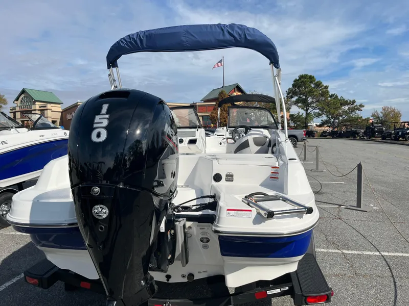 Slide: The Image of 2024 Tahoe 185 S boat with 150 HP engine in a parking lot. - 2