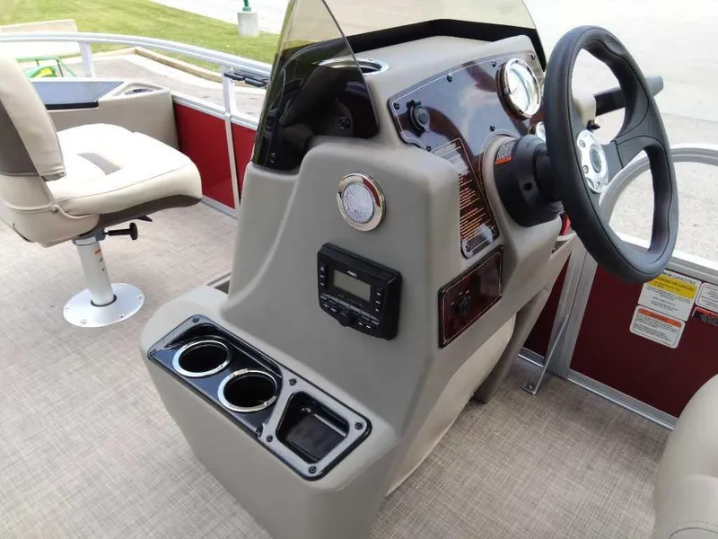 Slide: The Image of 2024 Sun Tracker Bass Buggy 18 DLX boat console with steering wheel and cup holders. - 4
