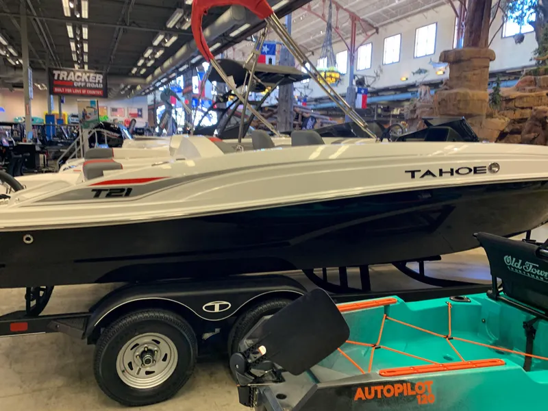 Slide: The Image of 2024 Tahoe T21 boat on display in a showroom with other watercraft. - 1